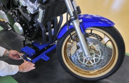blue motorcyce in a jack with hand